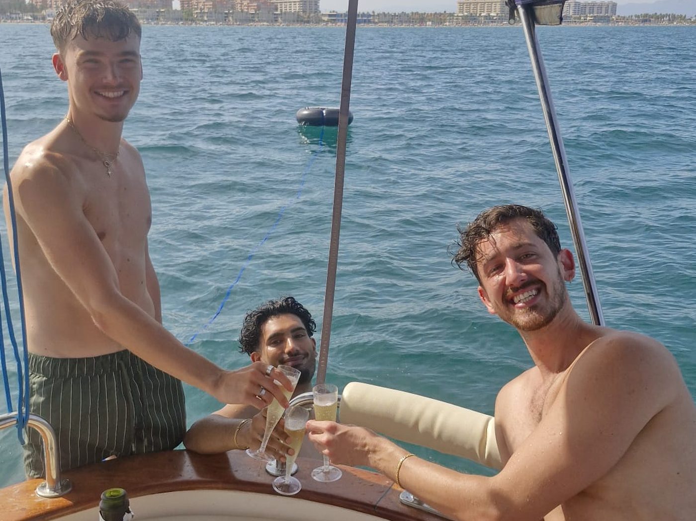 Amigos brindando con cava a bordo del Voramar frente a la costa de Valencia